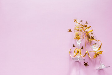 champagne glasses with confetti and streamer on pink background with place for text happy new year christmas holiday