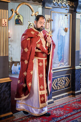 Religious priest holds holy Christian cross during religious chuch ceremony