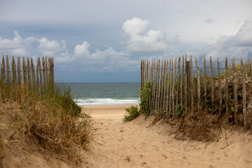 Fototapeta na wymiar path leading through the dunes of Soulac sur Mer, Medoc, France to the beach of the Atlantic ocean