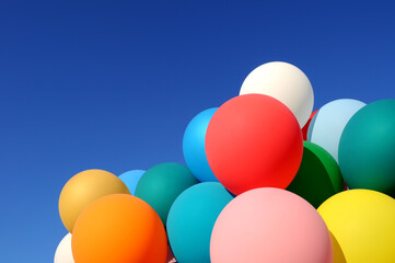 group of multicolored balloons in the city festival on clear blue sky background