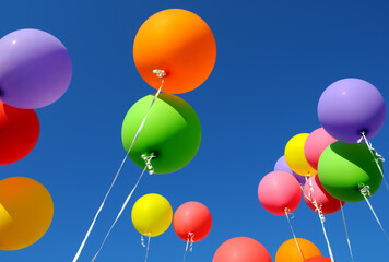 group of multicolored balloons in the city festival on clear blue sky background