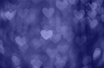 Violet abstract bokeh background in the shape of hearts. Valentines day texture. Trendy color very peri in the 2022 year.