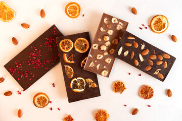 Natural organic milk and bitter chocolate bars with sublimated berries, orange slices, almond and hazelnut.