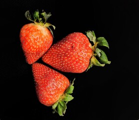 Three strawberries in a Black background