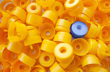 Plastic yellow caps fill the entire frame, one blue among the yellow. Another. Stand out.
