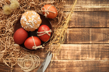 Easter eggs and cupcake on a dark wooden background. Selective focus, top view