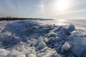 Obraz premium Lake Khanka in the Primorsky Territory in winter. View from above. Frozen coast of a large lake. Arctic landscape. Overall plan. Ice hummocks of a large lake.
