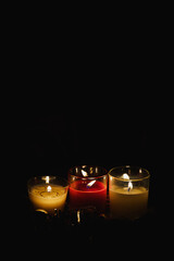 Three Christmas candles decoration glowing in the dark vertical