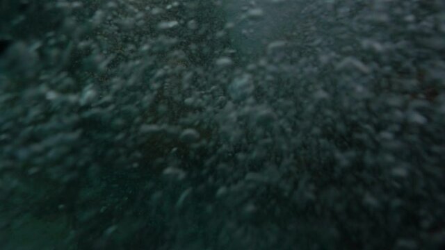 The camera is immersed under the water and over the sea in the drowning sea. Beautiful light refracts on the surface of the waves, diving, snorkeling.