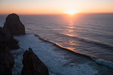 View of the rocks rasing in amazing sunset light at Atlantic coast in Portugal near Cabo Da Roca.