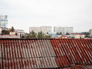 Brown roof of old slate on the background of urban houses