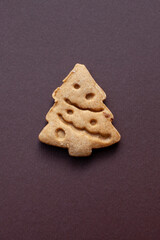 christmas tree shaped cookie on brown background