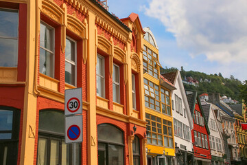 Typical street in Bergen, historic architecture, colourful wooden buildings and Floyan mountain in the background on a summer day. Norway.