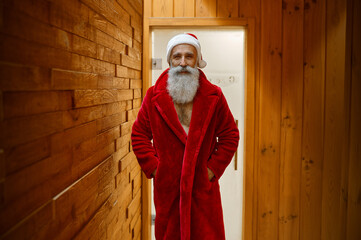 Santa Claus in red bathrobe in sauna
