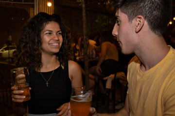 Young pretty latina flirts with young man in a bar.