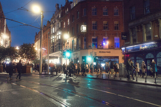 Dublin, Ireland - 12.11.2021: Night Scene. Crowd Of People Walking Towards Grafton Street. City Lights And Traffic. Soft And Dreamy Look