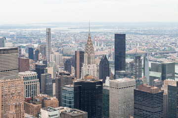 Fototapeta na wymiar Zoom in aerial panoramic city view of Upper Manhattan area, the East Side, river and Brooklyn neighborhoods on horizon, New York city, USA. Iconic cityscape of building exteriors of NYC