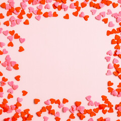 Happy Valentines Day concept. Frame made of red hearts on pink background. Flat lay, top view, overhead.