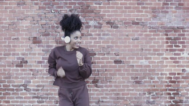 Happy young african american woman having fun while dancing in the street. High quality 4k footage