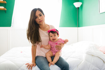 Portrait of a tired mom with her new born baby
