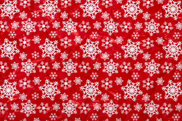 White snowflakes on a red background crumpled  wrapping paper. Christmas Holiday concept.