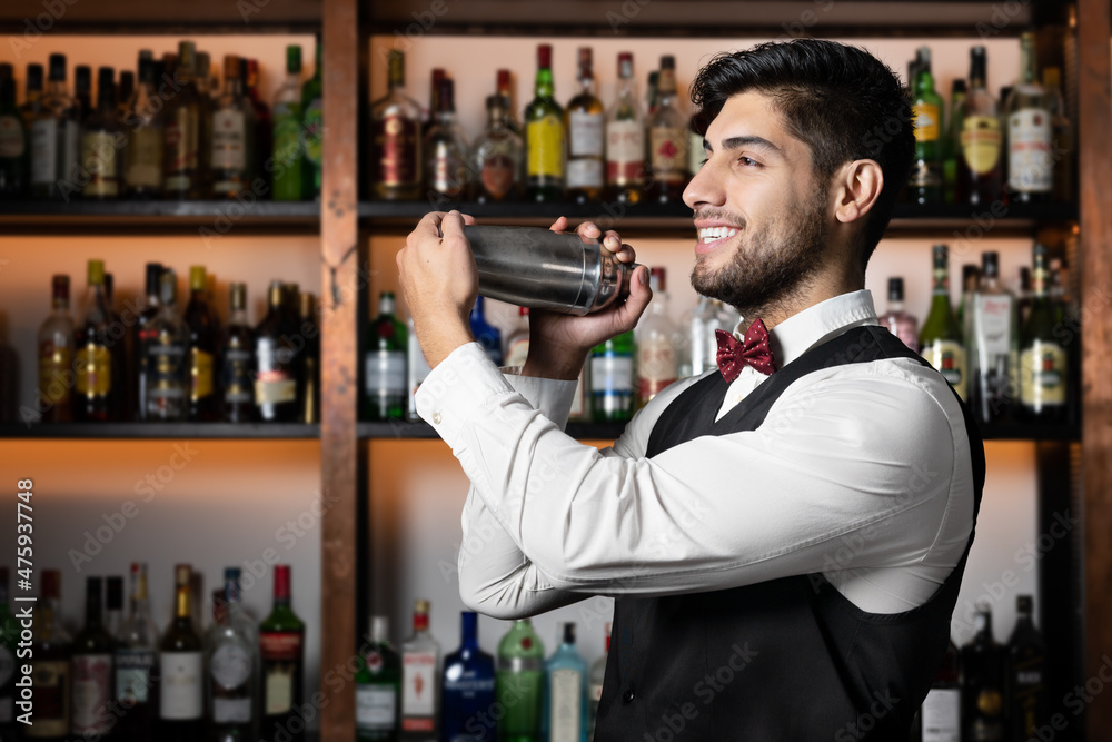 Wall mural bartender shaking cocktail shaker in cocktail bar. high quality photo