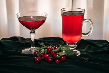 Red fruit flavored cider accompanied by cherries, on an elegant black cloth