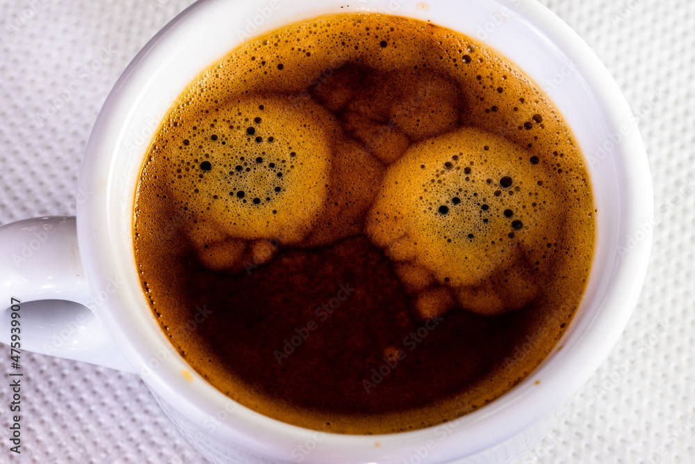 Canvas Prints Closeup shot of a cup of coffee on white cloth