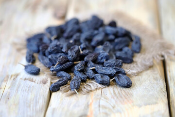 Selective focus. Macro. Blue raisins on a wooden surface.