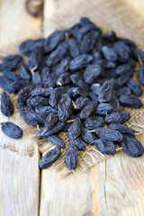 Selective focus. Macro. Blue raisins on a wooden surface.