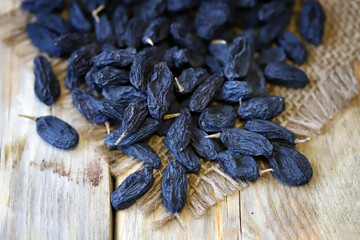 Selective focus. Macro. Blue raisins on a wooden surface.