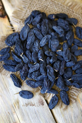 Selective focus. Macro. Blue raisins on a wooden surface.