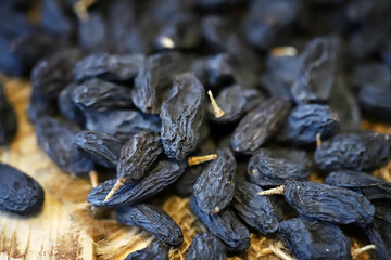 Selective focus. Macro. Blue raisins on a wooden surface.