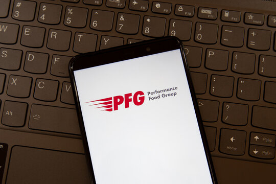 Toronto, On, Canada - December 19, 2021: PFG  (Performance Food Group Company) logo on the  smartphone screen on a keyboard. PFG is an American company that distributes a range of food products. 