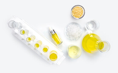 Cosmetic chemicals ingredient on white laboratory table. Candelilla Wax, Microcrystalline wax, Yellow cosmetic color (oil), Nickle chloride liquid and alcohol.