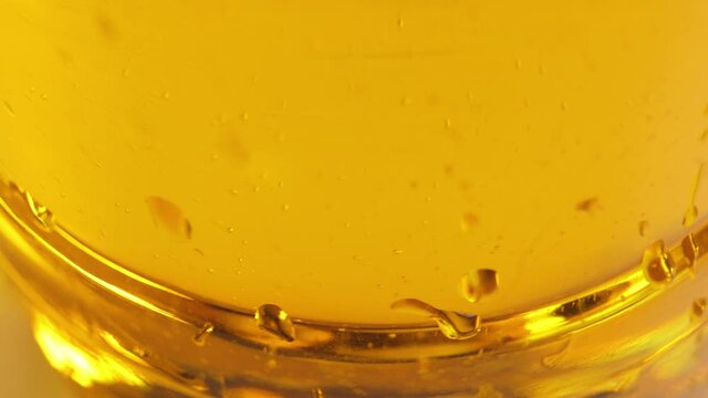 Vegetable oil in motion. Yellow liquid close up.