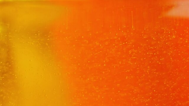 Beautiful orange and yellow abstract background. Transparent liquid with bubbles in motion.