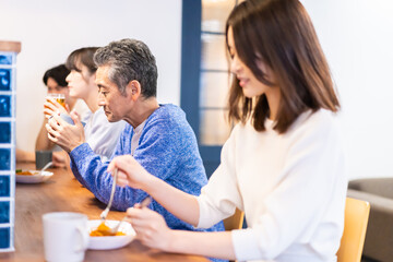 レストランのカウンター席でご飯を食べる人々