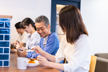 レストランのカウンター席でご飯を食べる人々