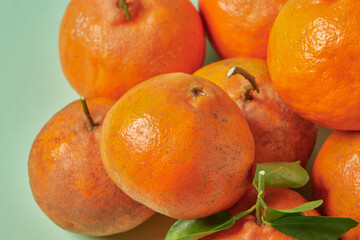 Fresh tangerines oranges on green background with a leaf