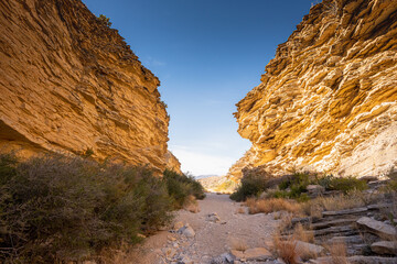 Thin Layers of Rock Form Tall Cliffs Flanking A Dry Wash