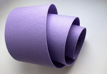 Purple felt is rolled into a tube on a white isolate. Production and sale of felt fabric.Purple fabric for needlework.