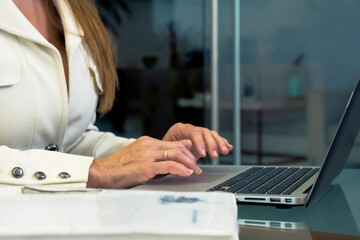 The closure of the female hands is using a laptop computer.