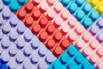 children's play background: the plane of plastic multi-colored bricks, blur, selective focus