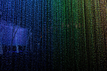 Tunnel rainbow of LED lights garland or many small lantern festival,colorful lighting bulbs decorated to curtain lamp on a bokeh with dark night background on Christmas day or Happy new year holiday.