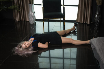 Crime scene simulation: dead girl with hands tied lying on the floor. She was strangled with a rope...