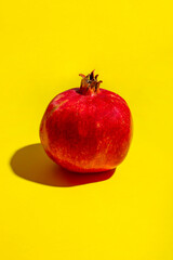 Ripe red pomegranate on yellow background