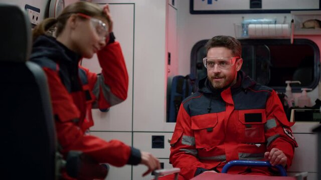 Emergency medical service team talking in ambulance car. Doctor waving head no