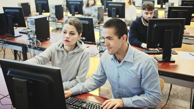 Man and woman study together in university computer class