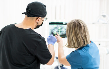 Obraz premium Two doctors checking x-ray image in hospital, quality photo 